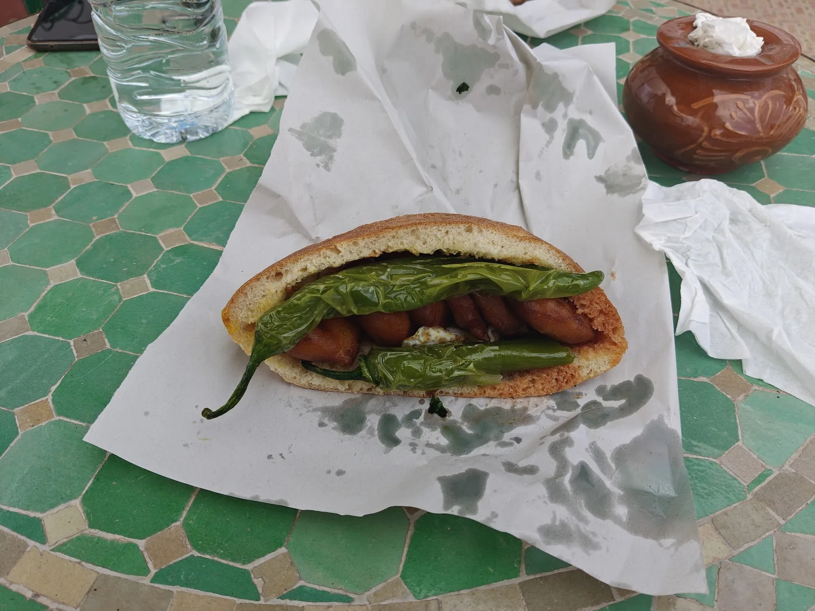 Sandwich ma3koda sur une table en mosaïque verte
